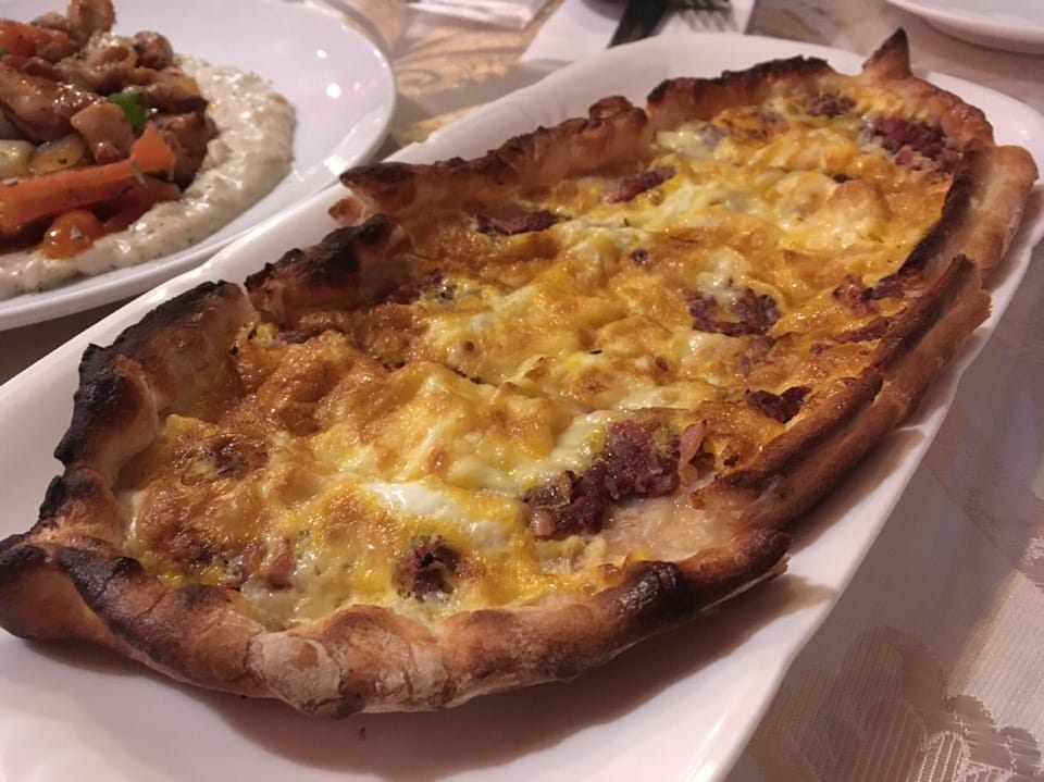 Turkish pide, with grilled chicken and meze alongside at Murat