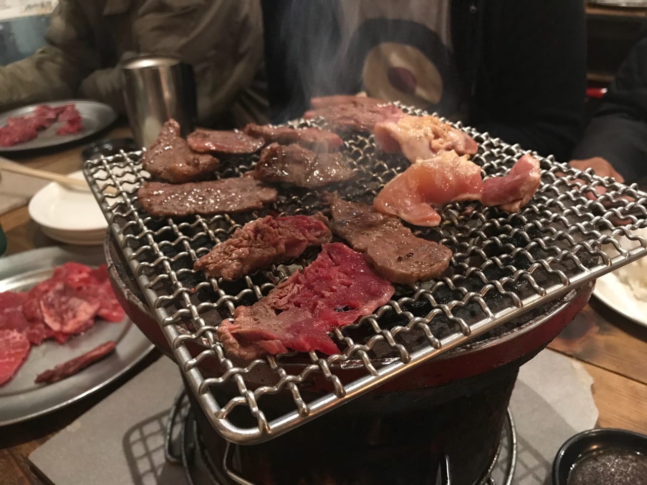 A5 wagyu and chicken laid out beside the charcoal brazier at the original yakiniku branch at Gyumon Shibuya