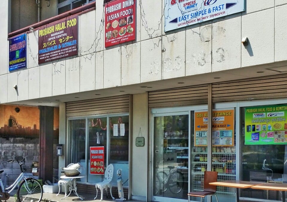One row of signs over a single frontage: halal groceries, an Asian food diner, a musalla and worldwide money transfer at PROBASHI, Maebashi
