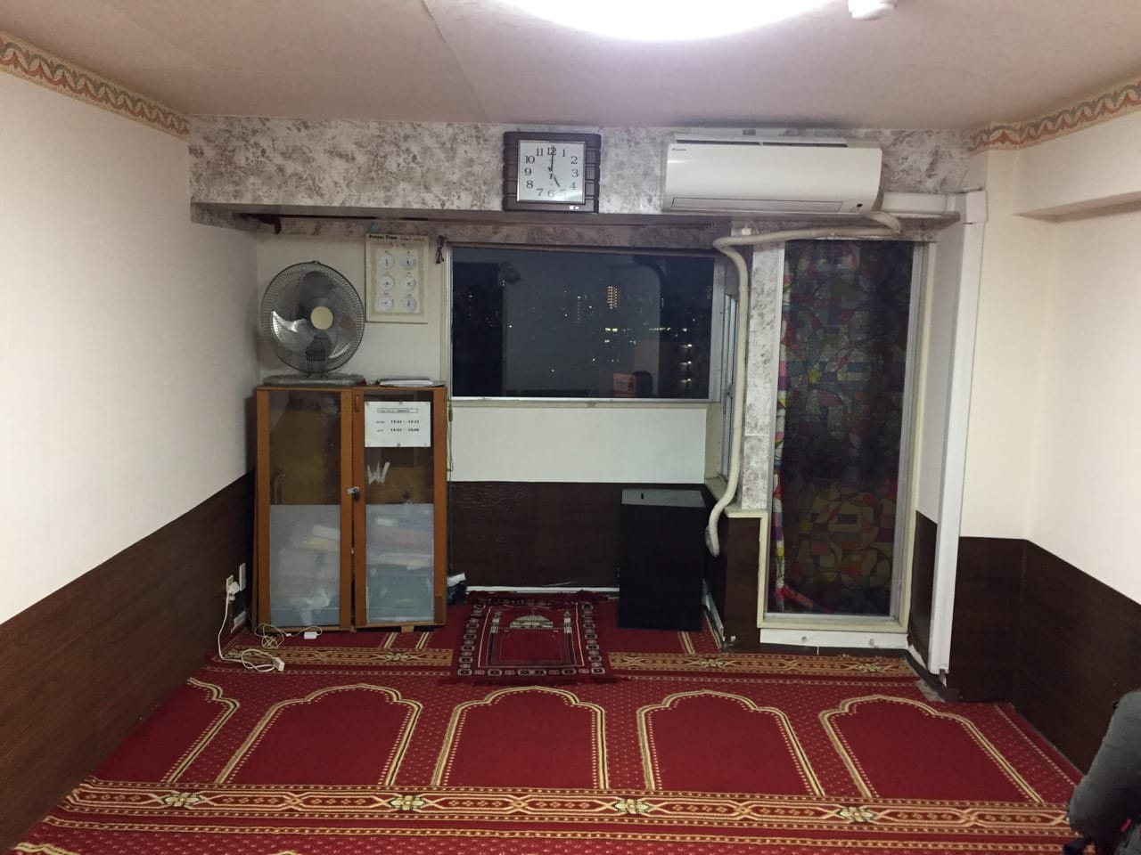 The prayer room with qibla-arched carpet at Shibuya Mushalla, Dogenzaka