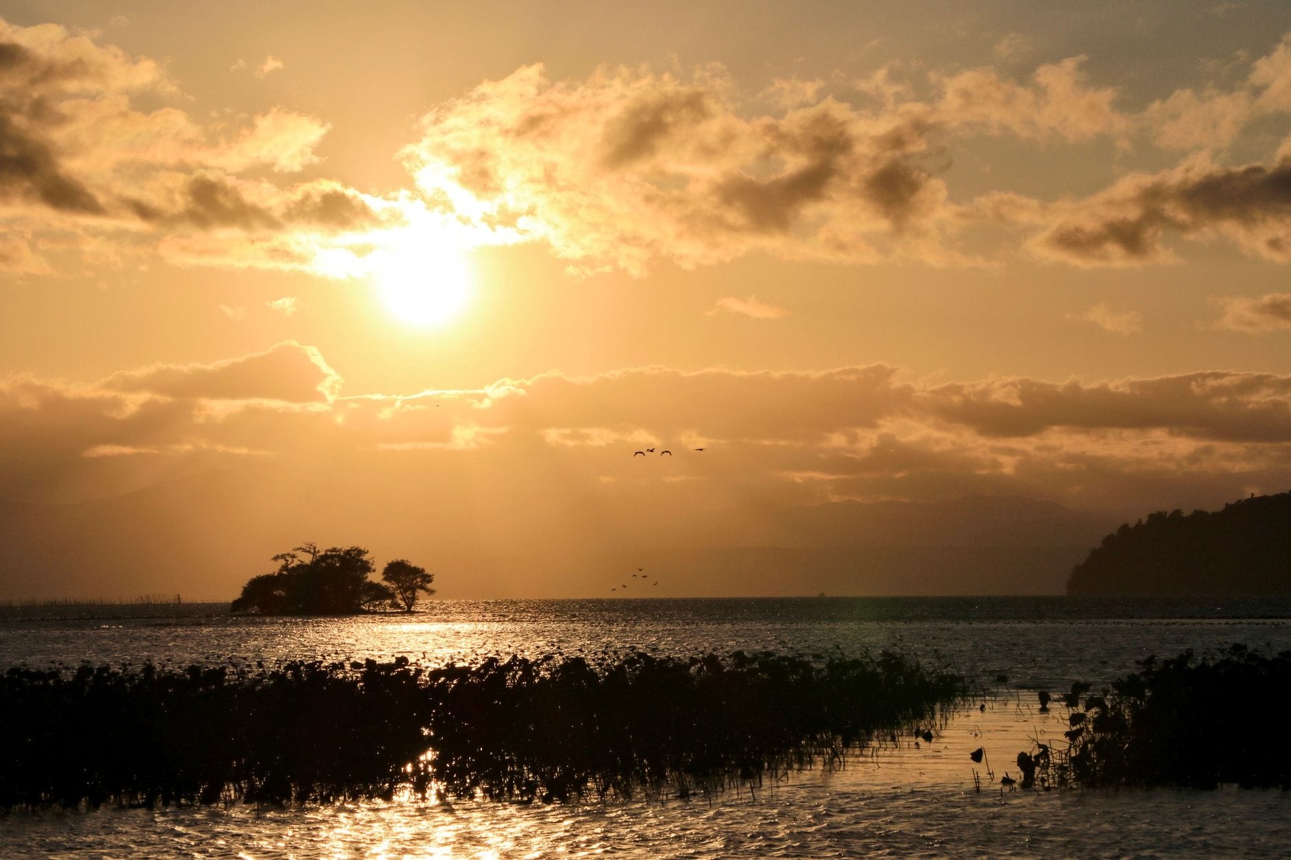 Sunset over Lake Biwa with a small island on the horizon