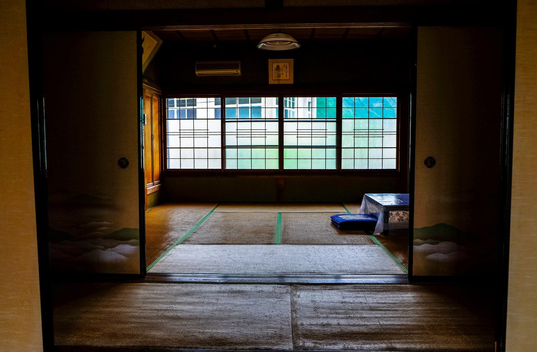 A quiet tatami room in a traditional Japanese inn, with light coming through the window