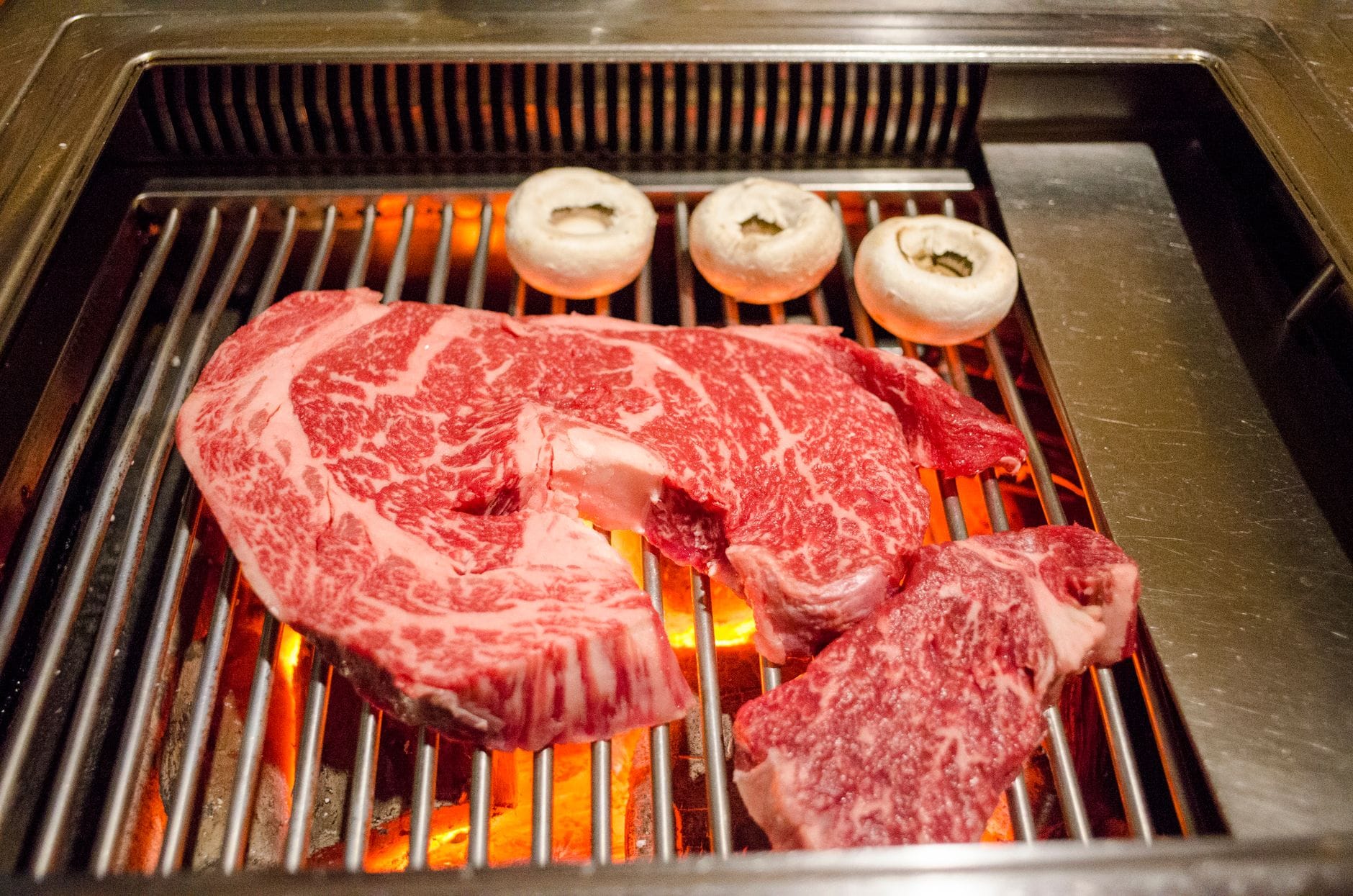 Marbled wagyu steaks on a grill